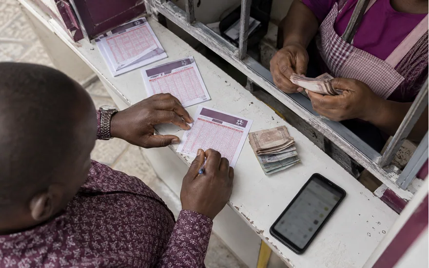 Customer and agent reviewing paper entries across a service counter