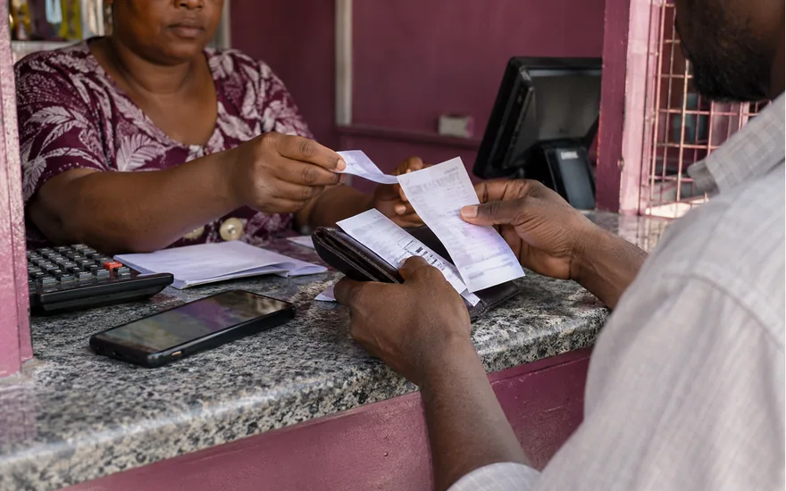 Customer and agent comparing a receipt across a plum service counter