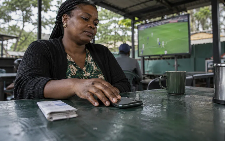 Woman resting a hand on a set aside phone at a quiet cafe table